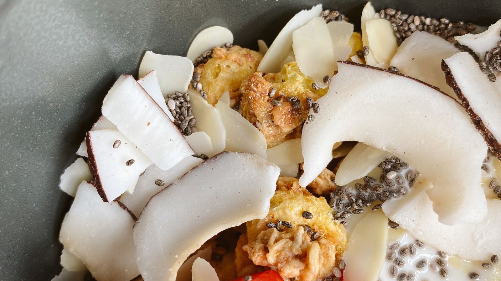 Bowl de desayuno con coco, chia y granola, imagen editorial sobre metabolismo y saciedad.