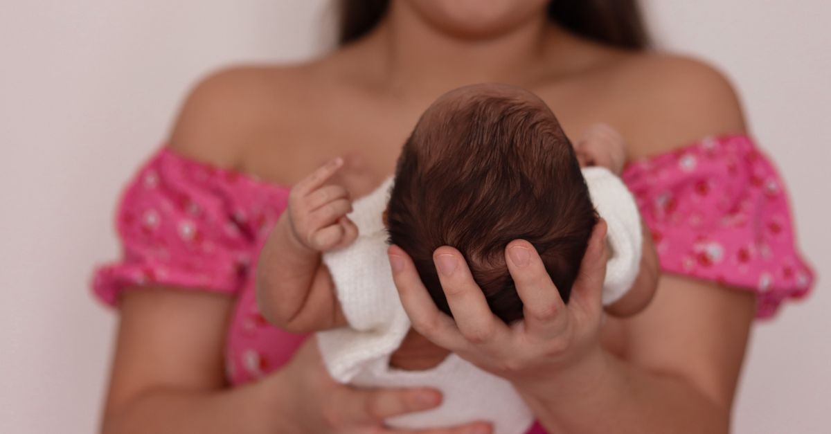 A mother gently cradles her newborn, symbolizing love and care.