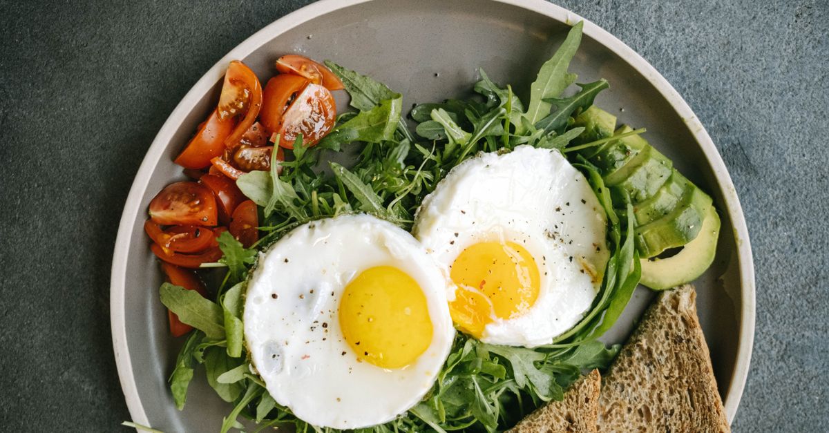 A delicious flat lay of a nutritious breakfast featuring eggs, avocado, and tomatoes.