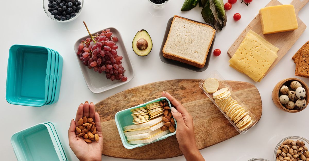 A vibrant flat lay of preparing a healthy snack with fresh ingredients like fruits, nuts, and cheese.