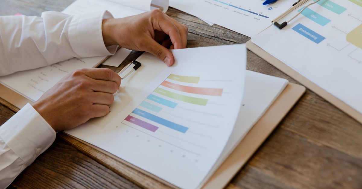 Manos revisando gráficos comparativos de resultados clínicos en un escritorio