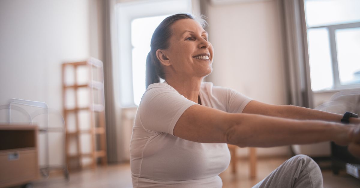 Happy senior woman exercising indoors, promoting active and healthy lifestyle.