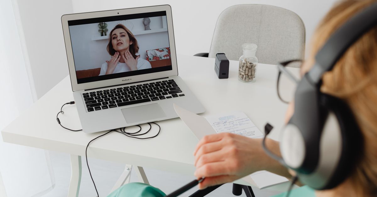 A healthcare professional video conferencing with a patient for an online consultation.