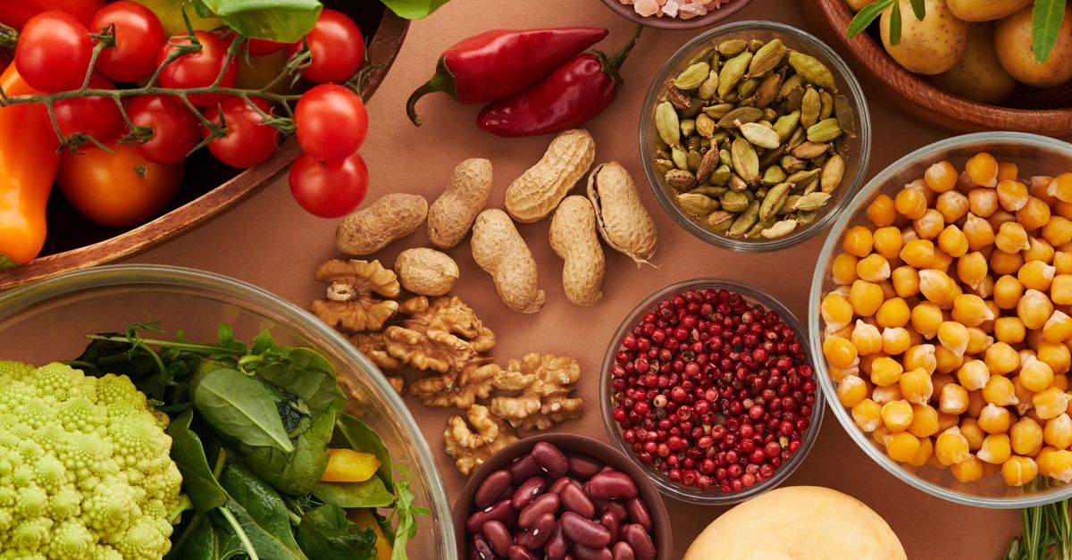 Explore a colorful assortment of healthy ingredients, featuring vegetables, nuts, seeds, and spices in a top view layout.