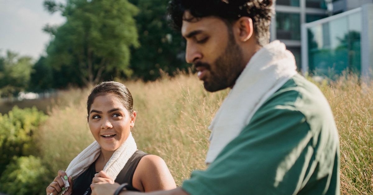 Two adults enjoying a moment outdoors after exercise, showcasing fitness and relaxation.