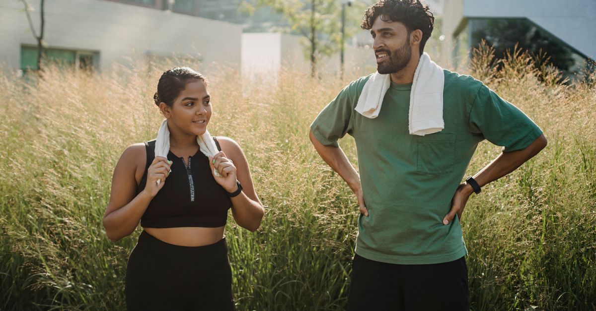 A man and woman exercising outdoors with towels, embracing a healthy lifestyle.