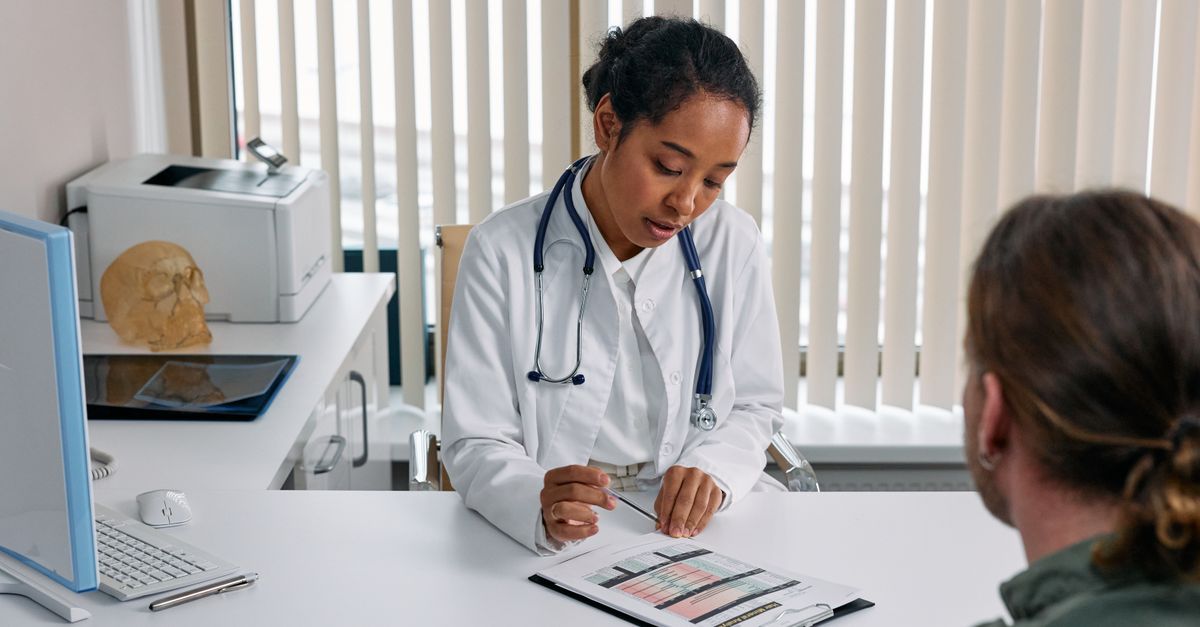 A doctor consulting with a patient in an office, discussing a medical chart.