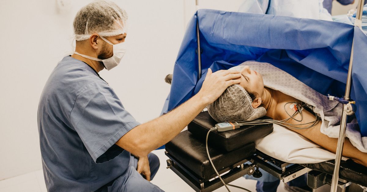 Surgeon offering comfort to a patient about to undergo surgery in a hospital operating room.