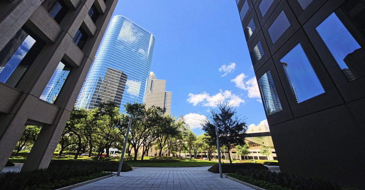 Modern skyscrapers framing the vibrant Houston skyline under a bright blue sky.